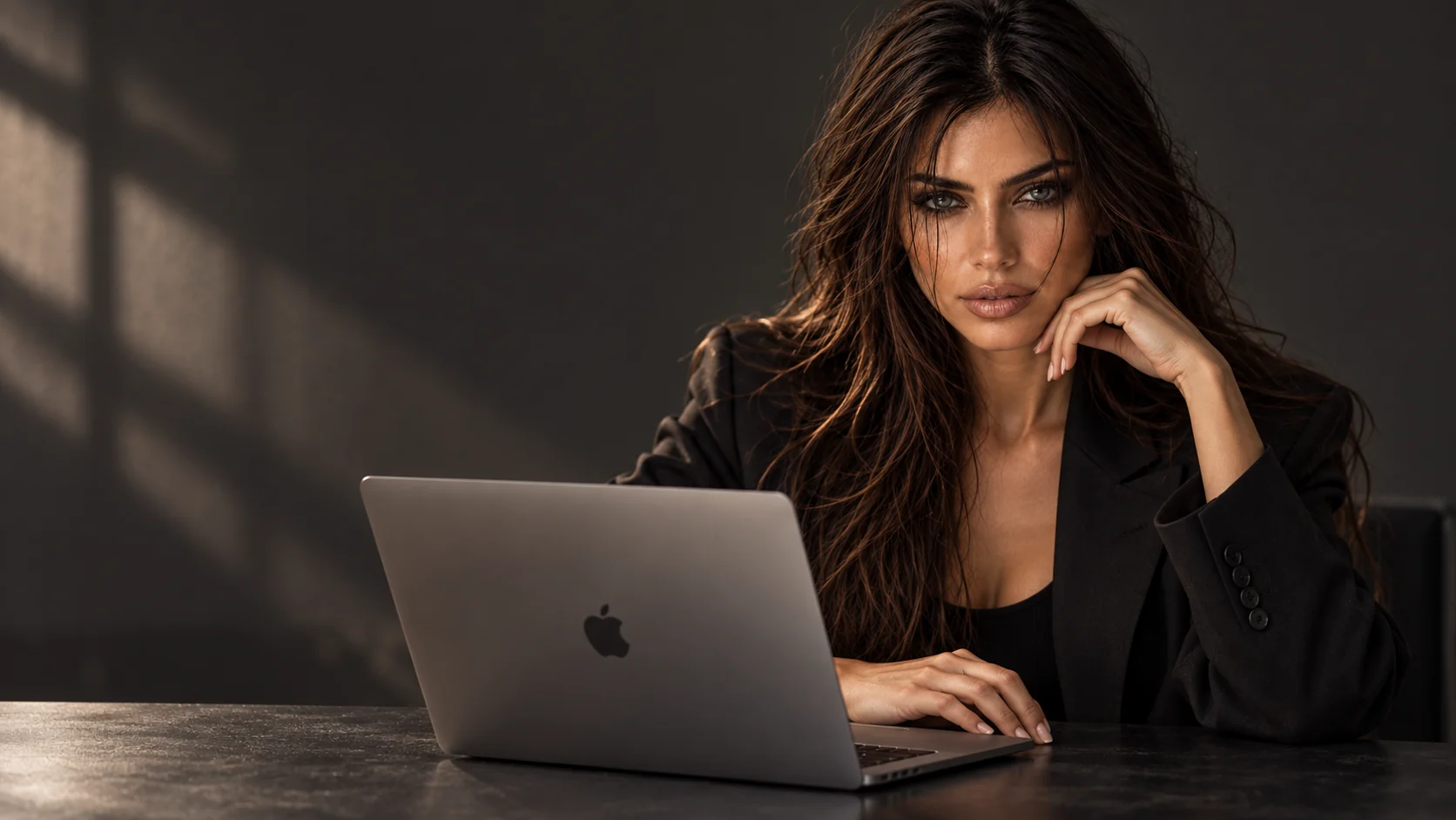 Rebecca davanti a un MacBook Pro in uno studio dalla luce cinematografica